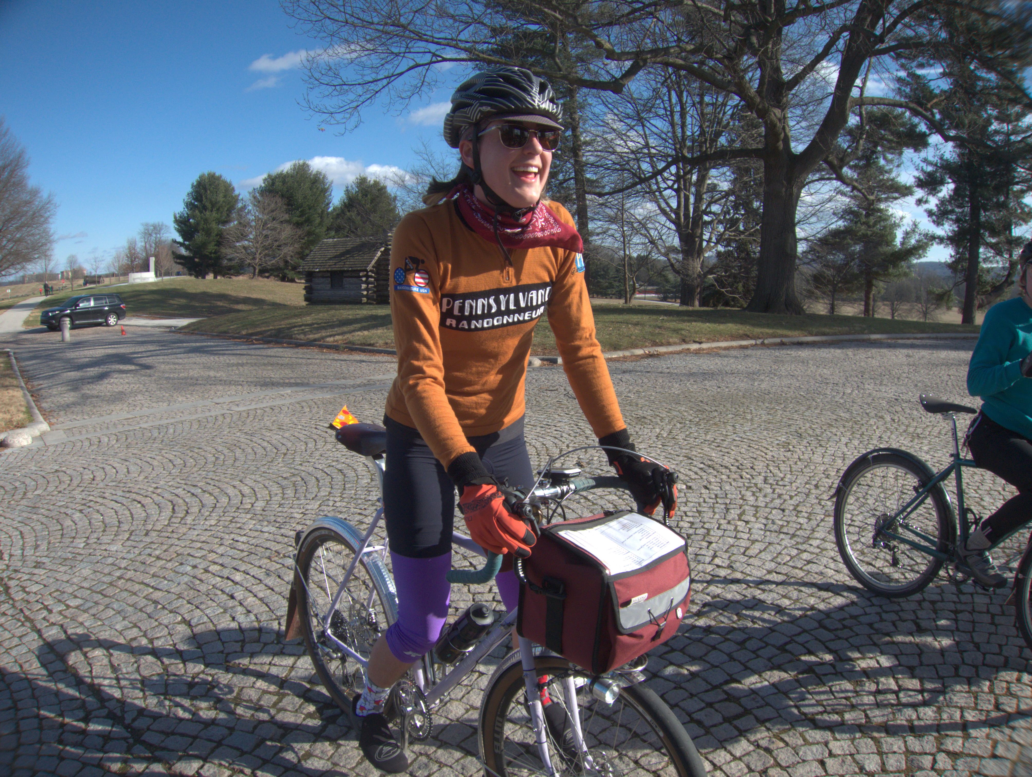 Natalie smiling on her bike in all her riding gear.