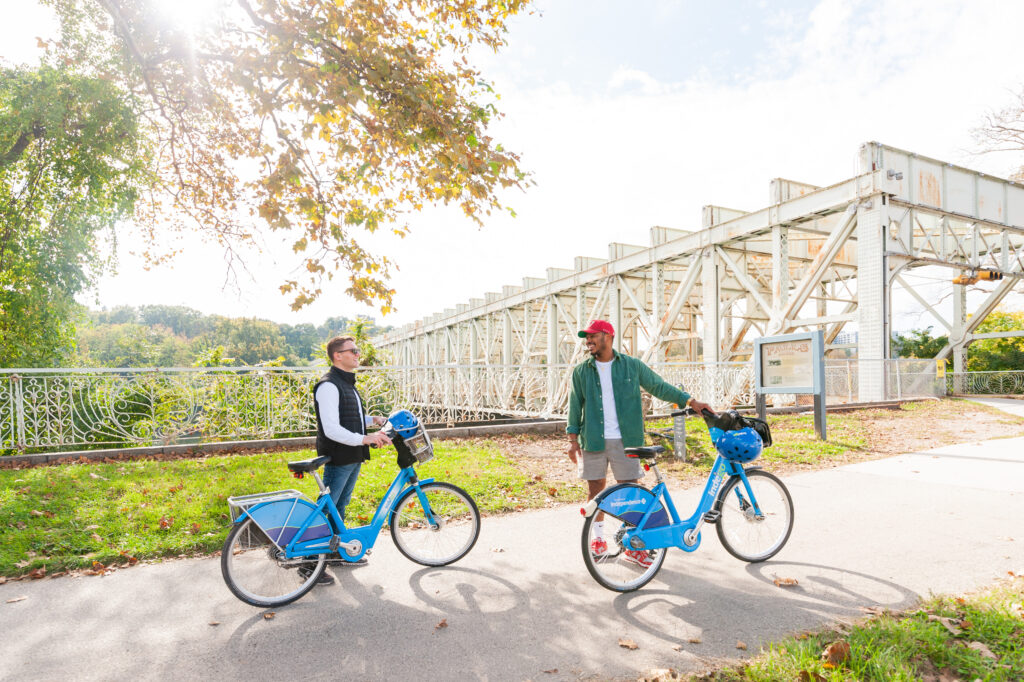 Two people with Indego bikes on the Schuylkill River Trail near East Falls