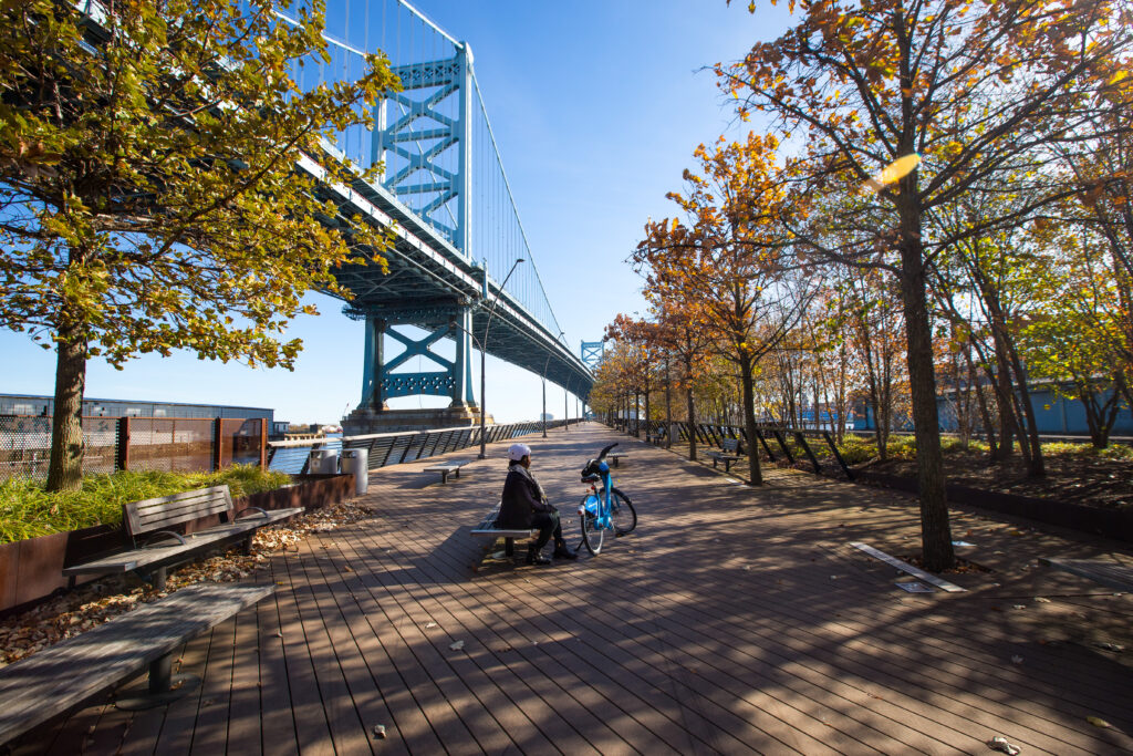 Person sitting on a bench under the Ben Franklin Bridge. *99977*